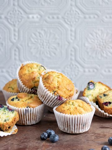 A pile of blueberry courgette muffins on wooden table