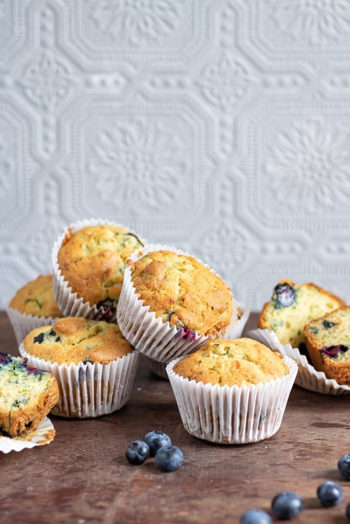 A pile of blueberry courgette muffins on wooden table