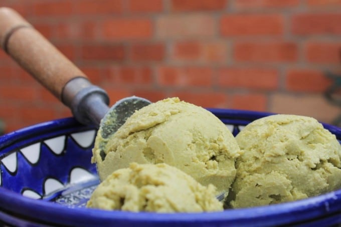 Pistachio Avocado Ice Cream in a bowl with ice cream scoop.