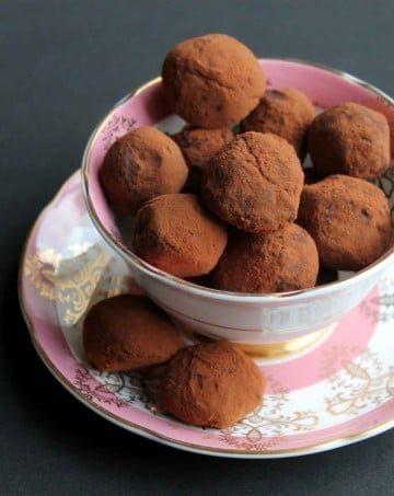 A vintage teacup full of chocolate truffles.