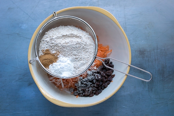 How to make easy carrot cake: Step 2 - Sift in the whole wheat flour, baking soda, baking powder, cinnamon and salt