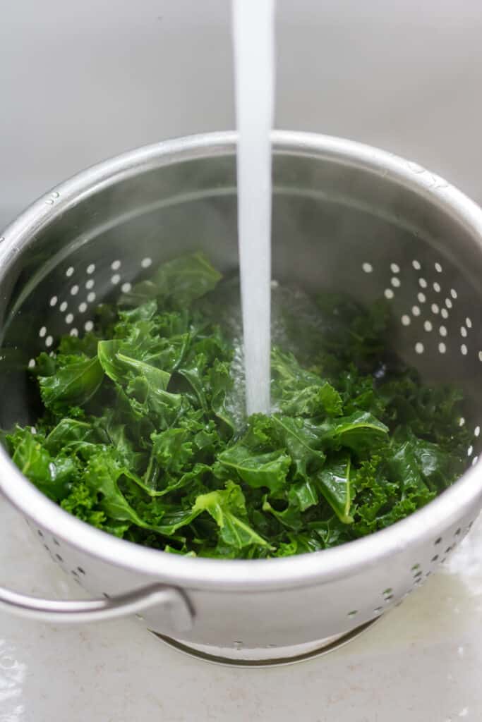 Rinsing steamed kale.