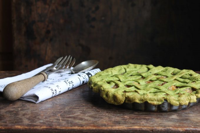 A green lattice pie on a wooden table.