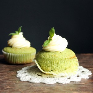 Two cupcakes on a wooden table.