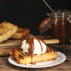 A slice of grilled cake topped with ice cream and caramel.