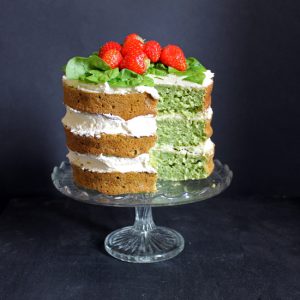 A cake on a cake stand, with a slice out.