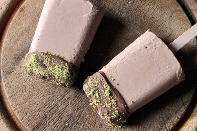 Chocolate Cauliflower Popsicles on a wooden board.