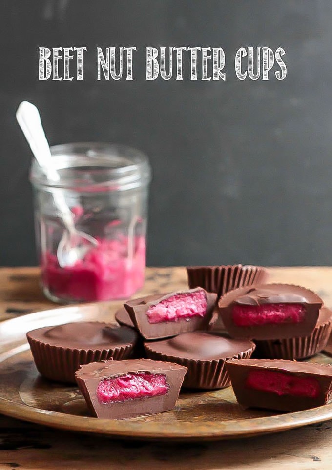 A pile of vegan chocolate candy - beet nut butter cups. Dark chocolate surrounds bright pink peanut butter filling (nut butter made with beets). Vegan, gluten free recipe.