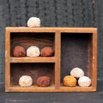A wooden box full of sweet potato balls.