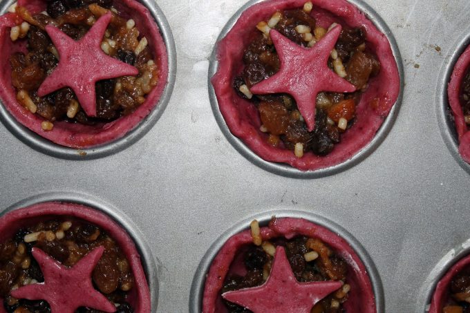 Uncooked mince pies with beet pastry ready to go into the oven.