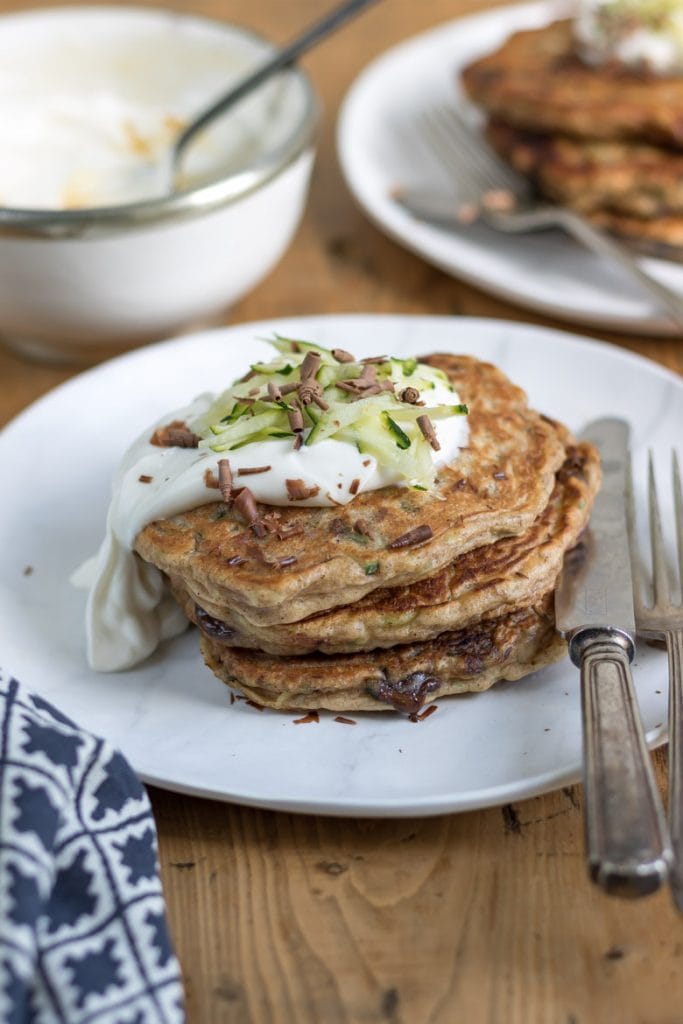 A stack of courgette pancakes topped with maple yogurt and chocolate