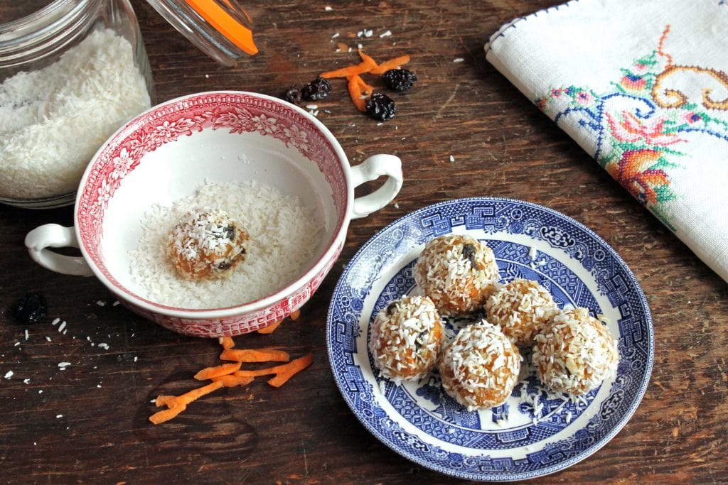 A table with a plate of protein balls and a jar of coconut.