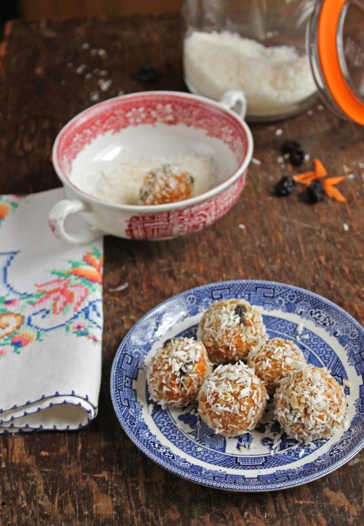 A table with a plate of protein balls and a jar of coconut.