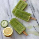 Cucumber popsicles on a marble board.
