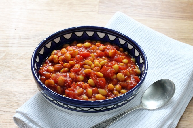 A blue bowl full of homemade baked beans with turmeric. 