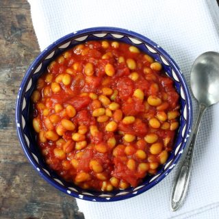 Bowl of baked beans on a table.