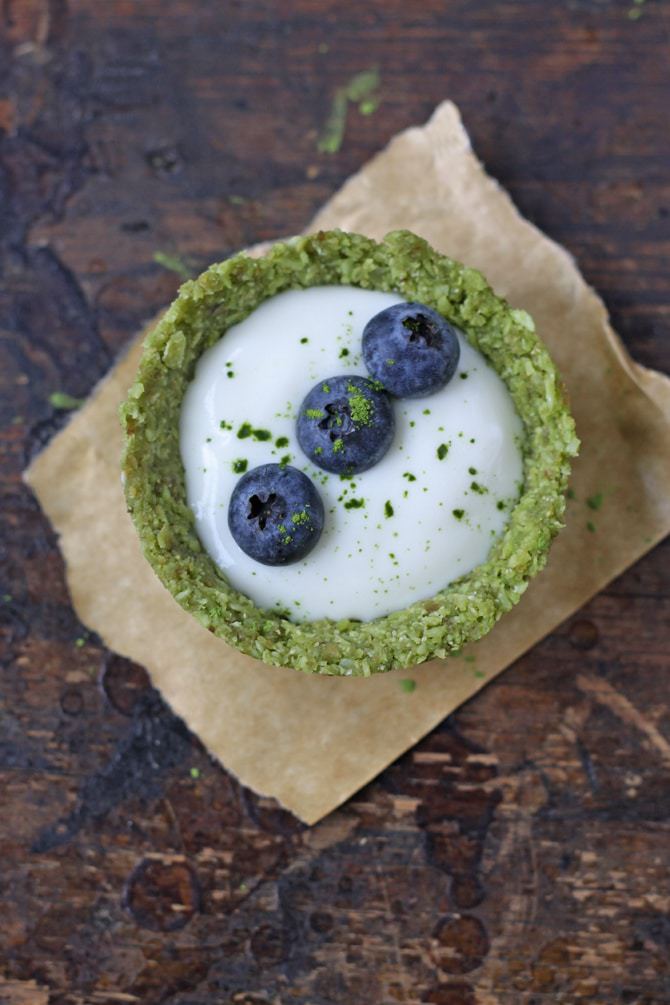 A tart filled with yogurt and a row of blueberries.