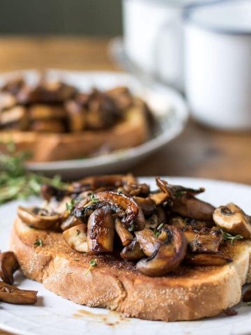 Mushrooms on toast with garlic and thyme. Shown as a vegetarian or vegan breakfast, brunch, lunch or dinner recipe.