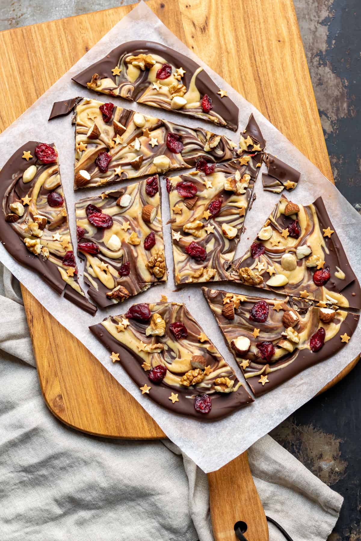 Cut shards of melted and re-hardened chocolate with dried cranberries, chopped nuts and star shaped sprinkles.