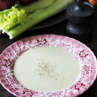 Bowl of blue cheese soup in front of celery sticks.