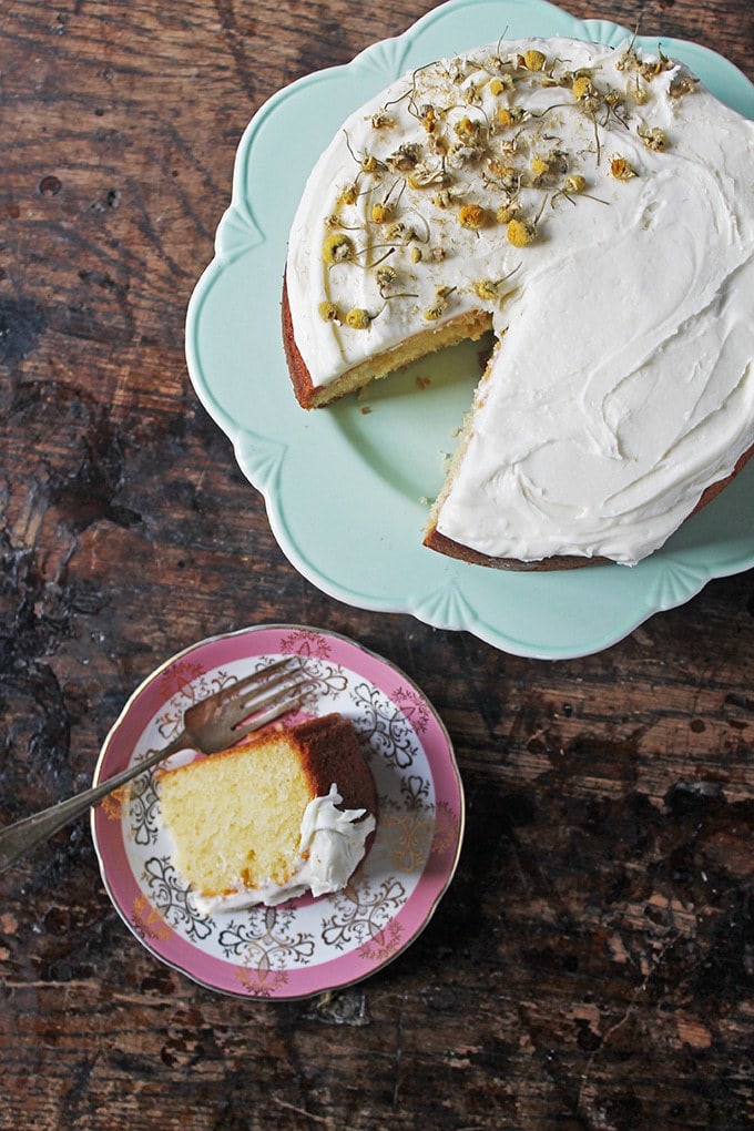 Chamomile Cake on a vintage cake stand with a slice cut out and served on a vintage plate next to it.