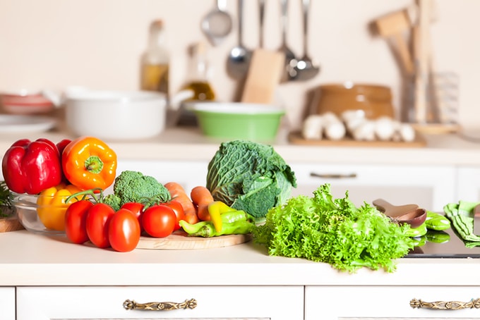 A kitchen counter covered in vegetables.