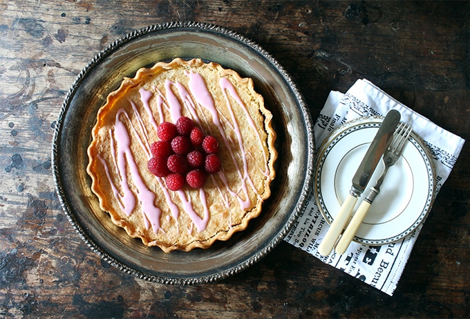 Table with a pie, plates and cutlery.