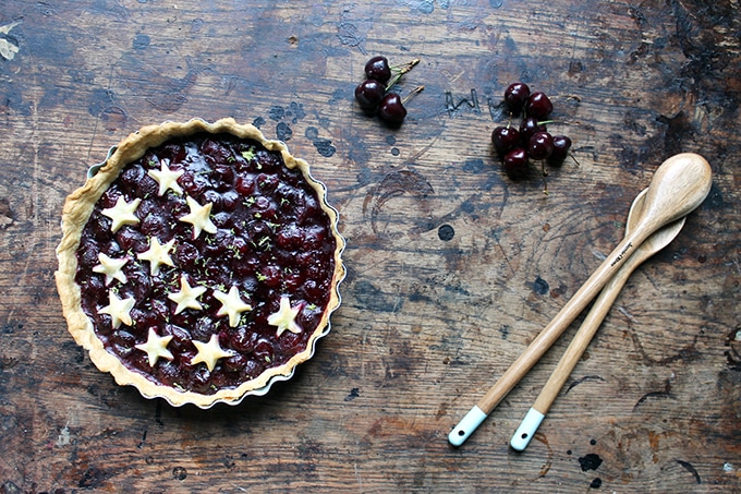 Cherry pie with pastry stars on a wooden table.