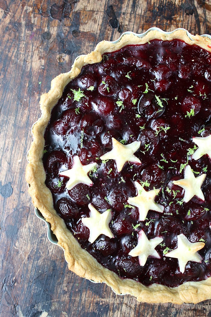 Close up of a cherry pie with pastry stars on half of it.