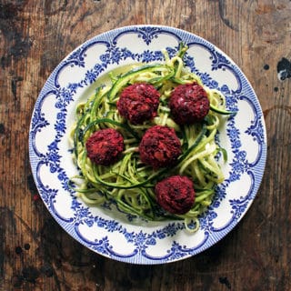 A close up of a plate of zoodles and meatballs.