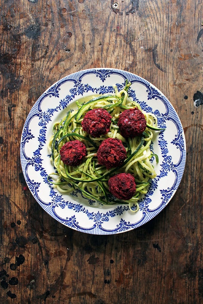 Plate of zoodles topped with vegan meatballs made from beets.