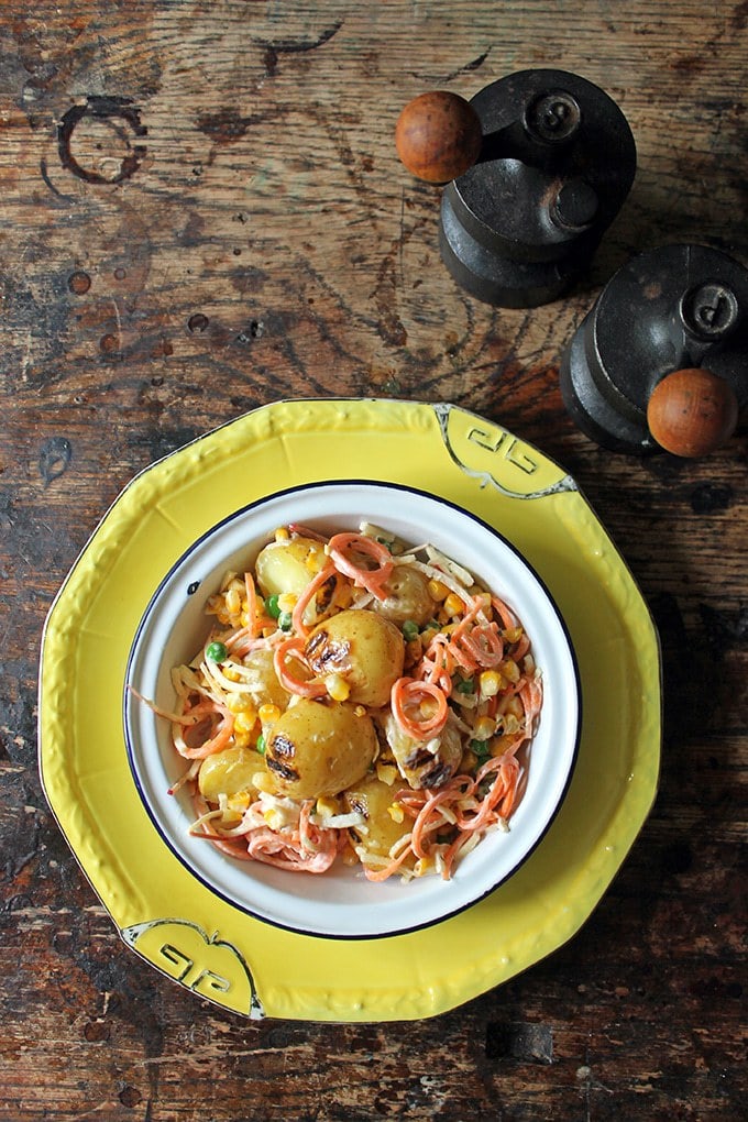 Salad on a plate, with potatoes, apple and carrots.