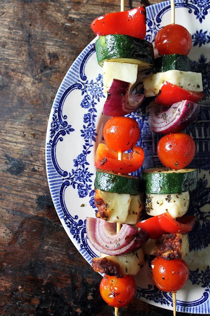 Skewers of halloumi and vegetables on a plate.