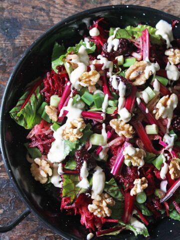 Close up of serving dish of beet salad with walnuts.