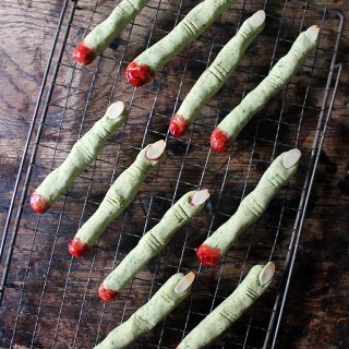 Rows of naturally green peanut butter Witch Finger Cookies that look scary - perfect for a Halloween party food.
