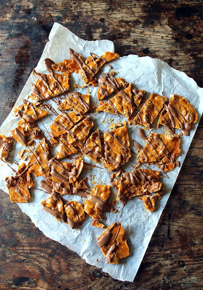 Chocolate drizzled on pecan brittle.