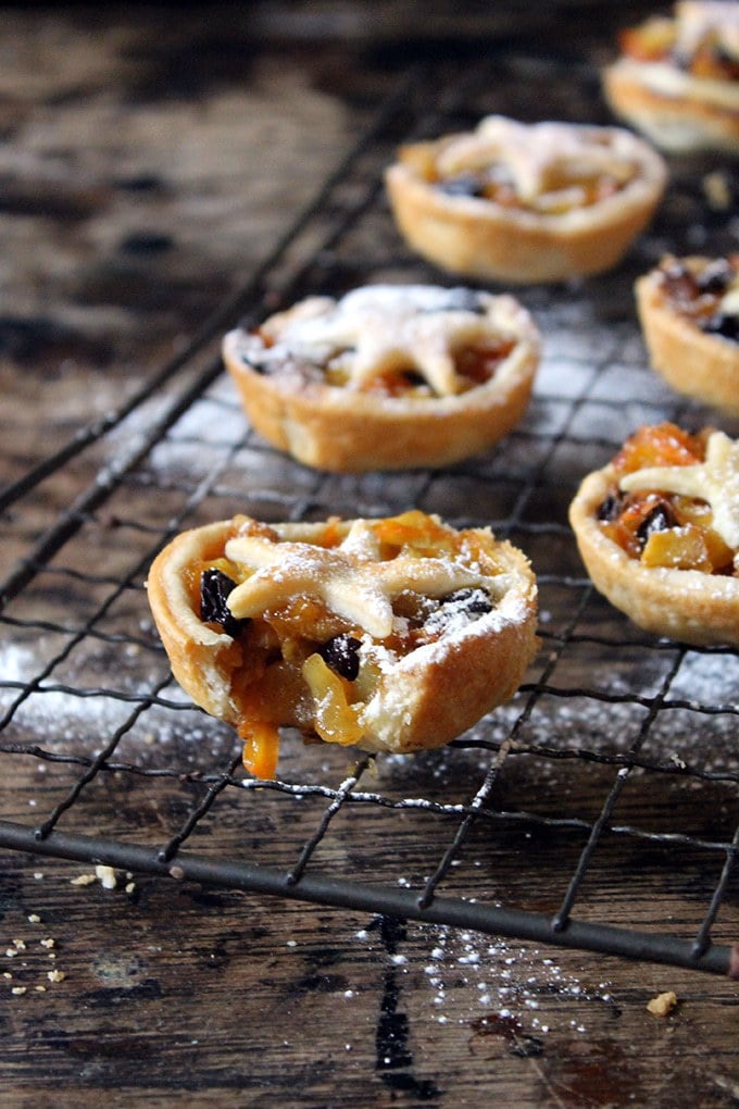 Close up of a bite out of a Carrot and Apple Mince Pie, in front of others on a cooling rack. 