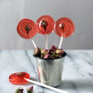 Lollipops sticking out of a metal cup.
