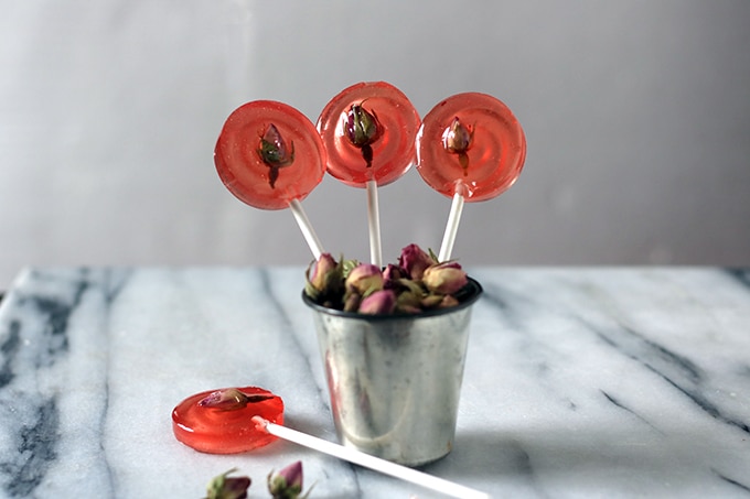 Lollipops sticking out of a metal cup.
