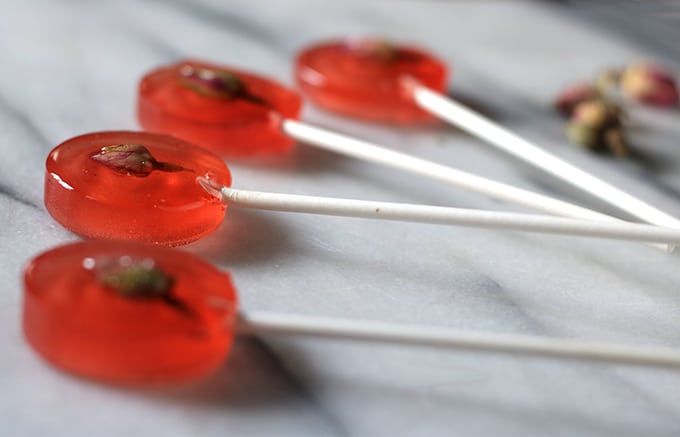Close up of lollipops lying on a marble counter.