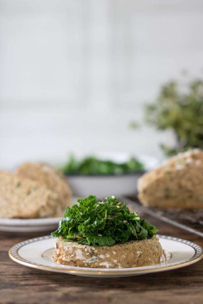 Bread on a plate topped with kale.