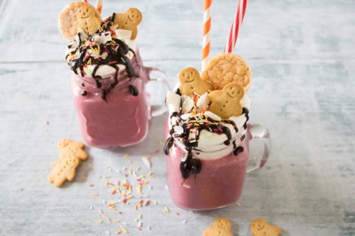 Glasses of smoothie with cream, cookie and chocolate sauce.