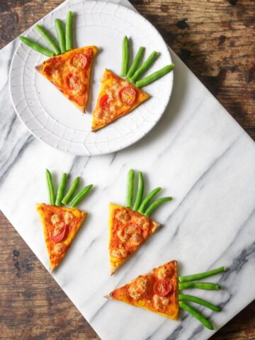 Slices of pizza on a plate and on a marble board.