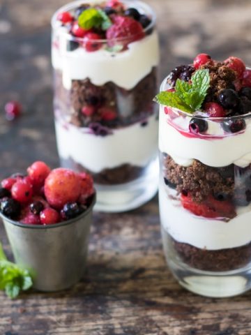 Glasses of layered yogurt, cookies and fruit.