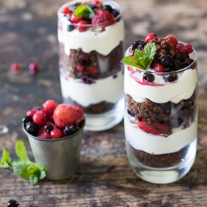 Glasses of layered yogurt, cookies and fruit.