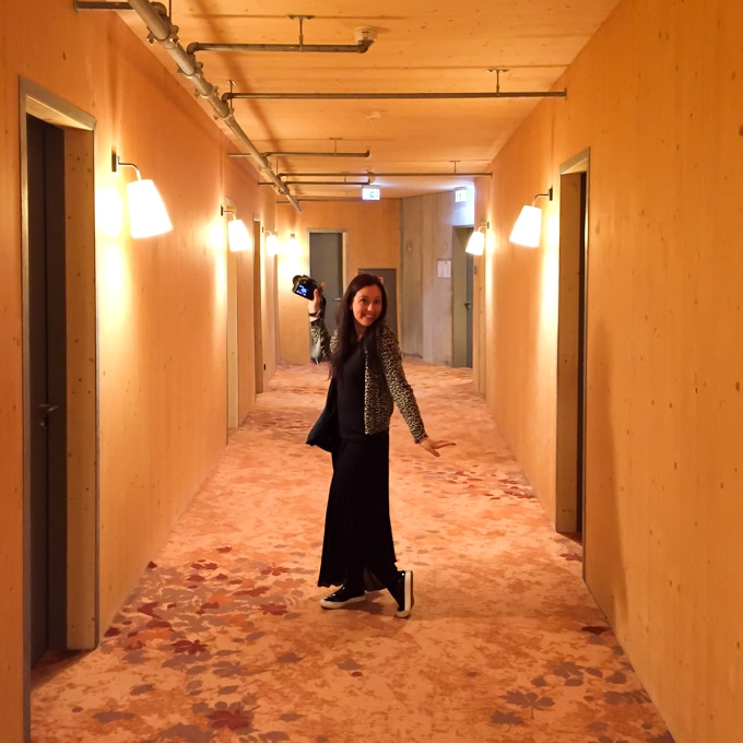 A person standing in a hotel hallway.