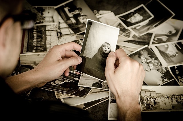 Person holding vintage photos.