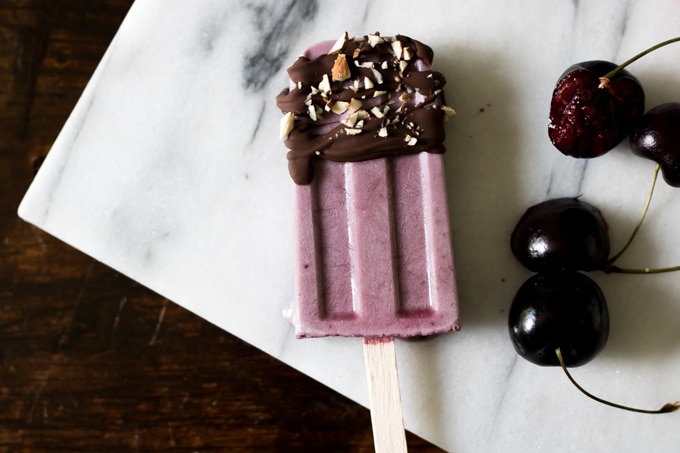 Close up of a cherry popsicle with chocolate topping.