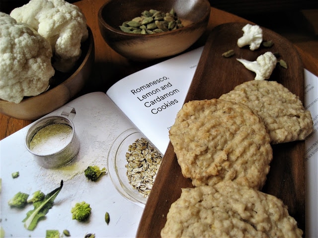 Cookies and a cookbook on a table.