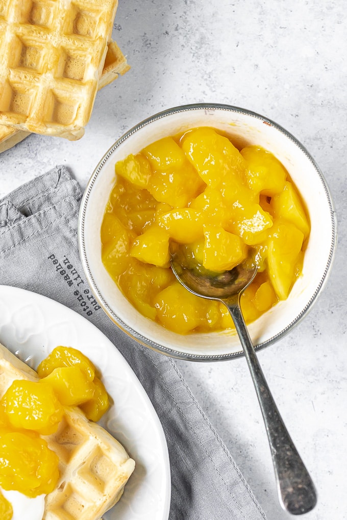 Disque de compote de mangue à côté de gaufres.